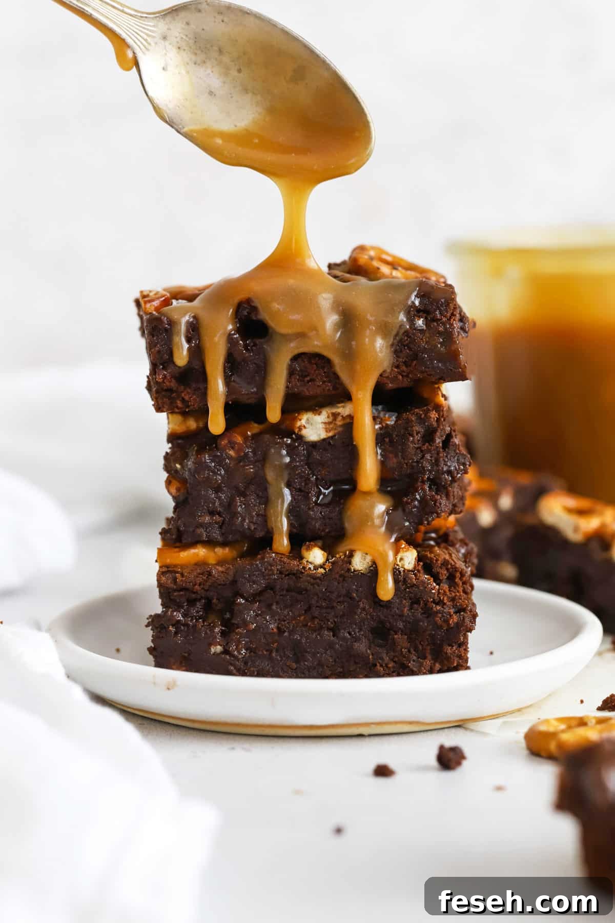 Drizzling caramel sauce on gluten-free caramel pretzel brownies
