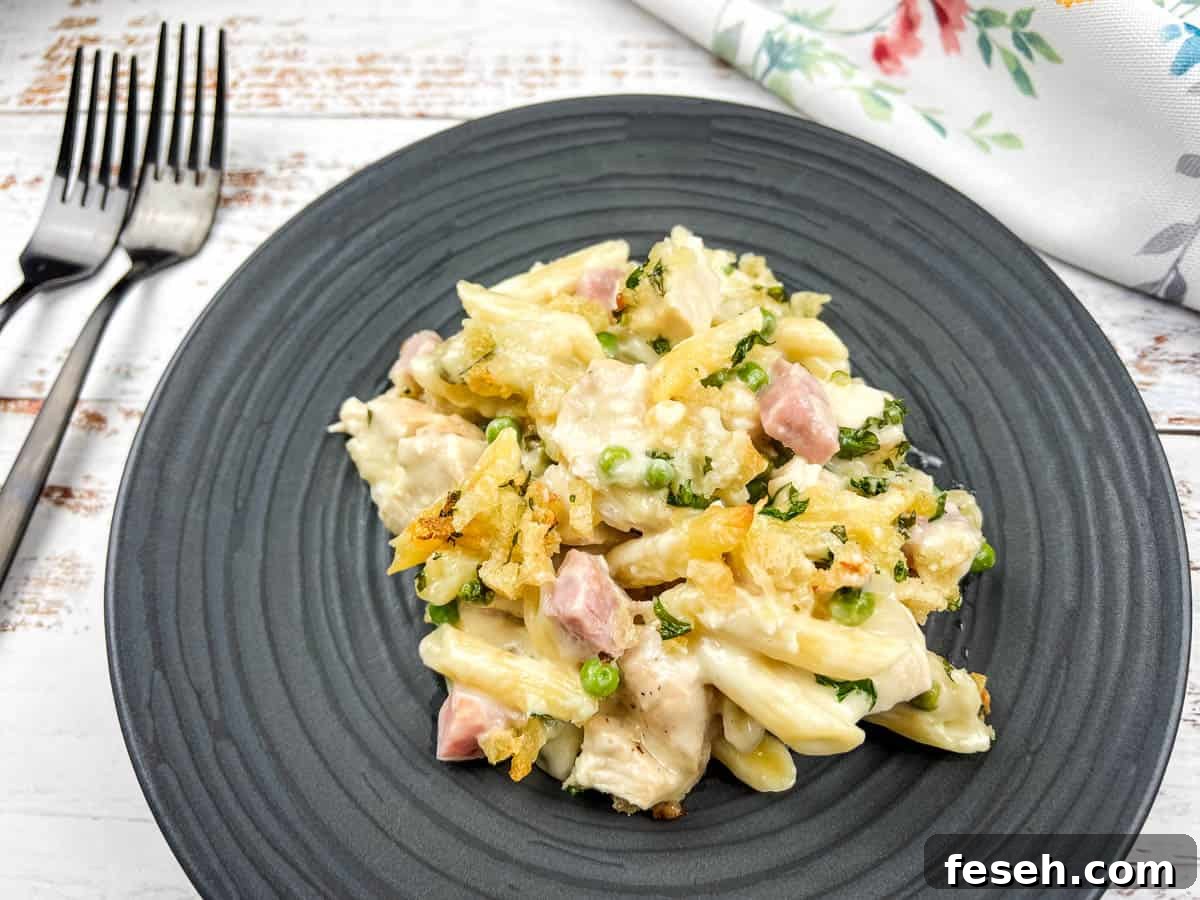 17 Pantry-Friendly Nanna Casseroles That Taste Homemade and Luxurious 16 Chicken cordon bleu casserole on a black plate with a fork.