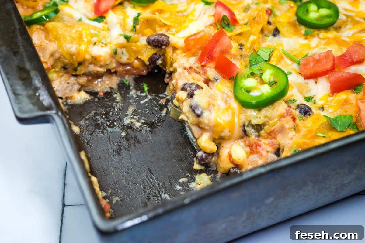 17 Pantry-Friendly Nanna Casseroles That Taste Homemade and Luxurious 19 A close-up of a partially eaten cheesy Mexican chicken casserole in a baking dish.