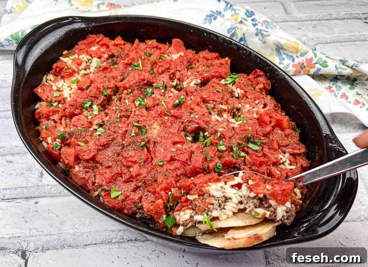 17 Pantry-Friendly Nanna Casseroles That Taste Homemade and Luxurious 3 Shipwreck Casserole in a black dish with a spoon.