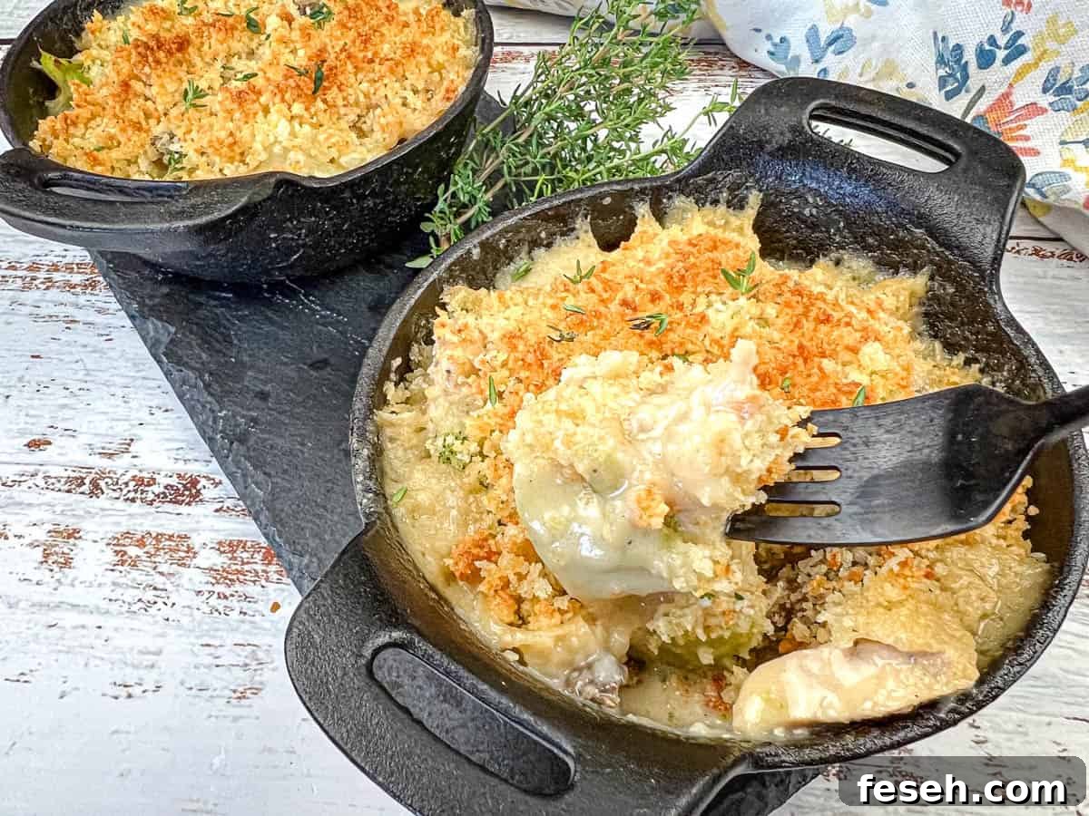 17 Pantry-Friendly Nanna Casseroles That Taste Homemade and Luxurious 5 Two cast-iron skillets filled with vintage chicken divan and a fork dishing up one serving.