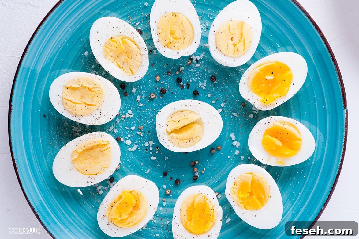 sliced soft and hard cooked eggs arranged in a flower patter and sprinkled with salt and pepper on a teal plate