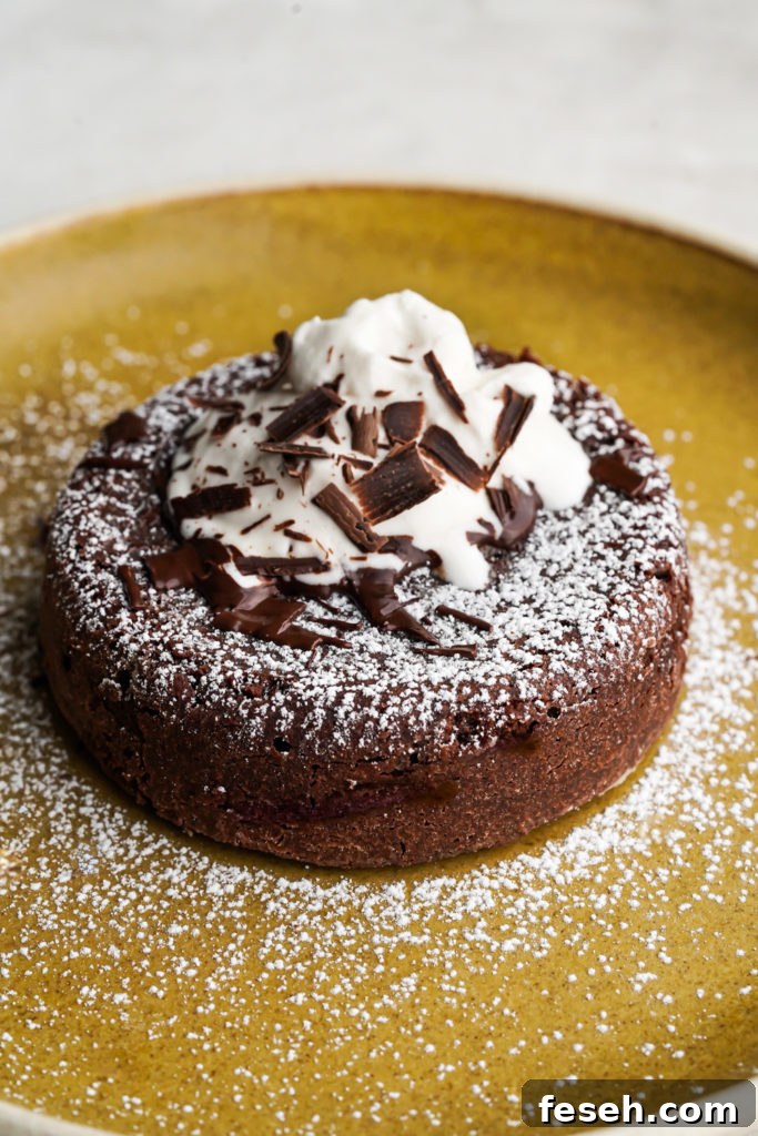 molten lava cake topped with powdered sugar, chocolate chips and whipped cream