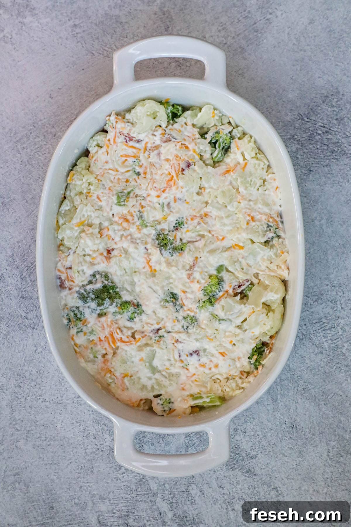 A white dish with broccoli and cheese casserole.