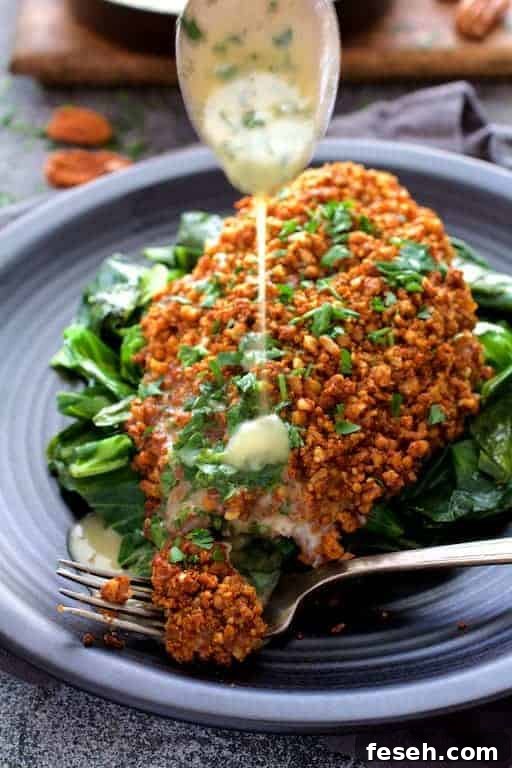Baked Catfish Pecan Meuniere with butter being drizzled over a piece.