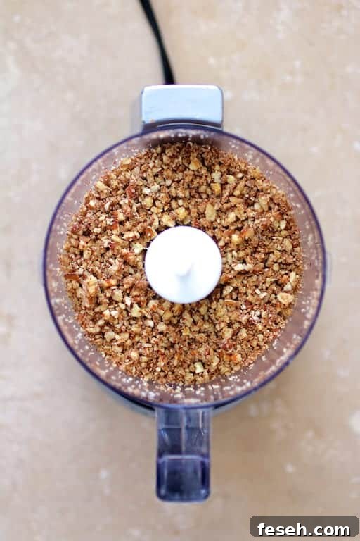 Photo of ground pecans in mini food processor.
