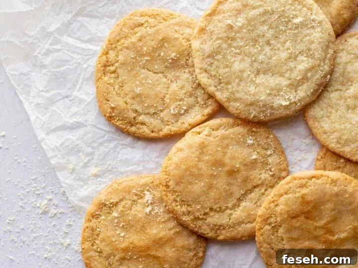 Nine golden cookies on wrinkled baking paper.