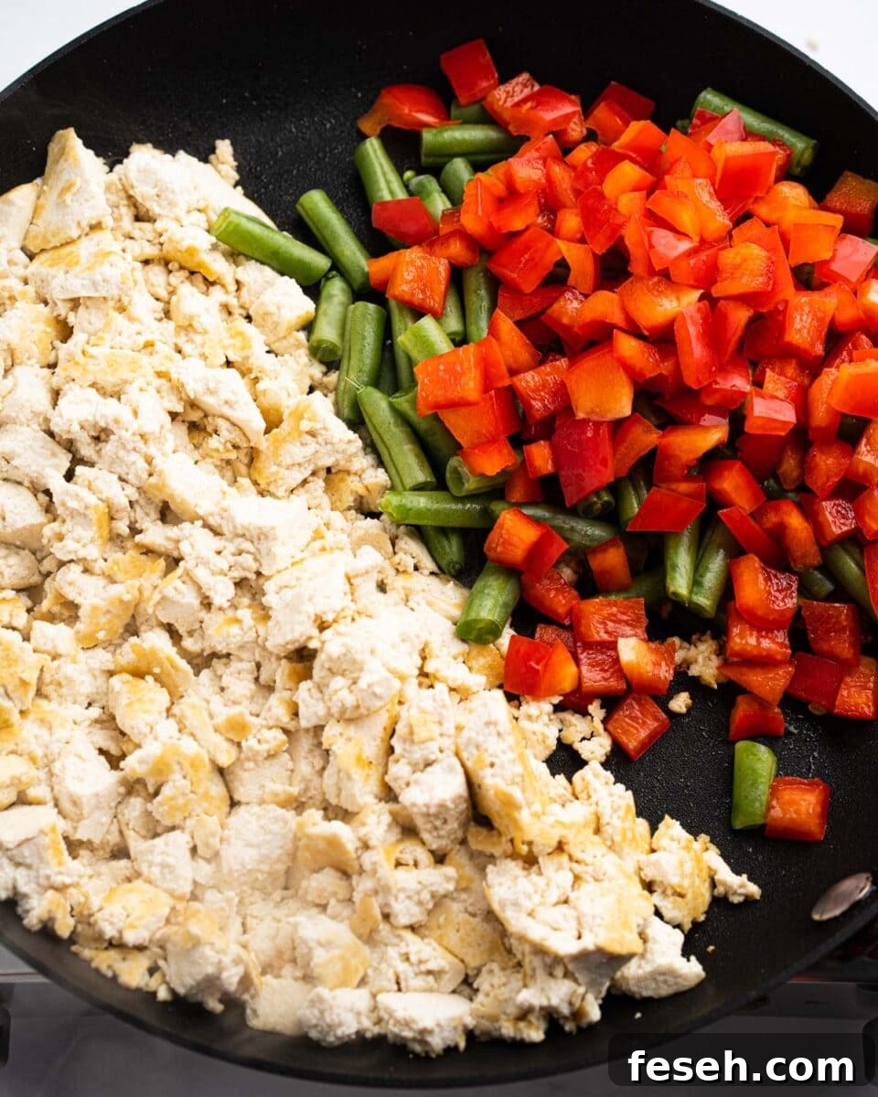 pan with stir fried tofu, green beans and red bell peppers.