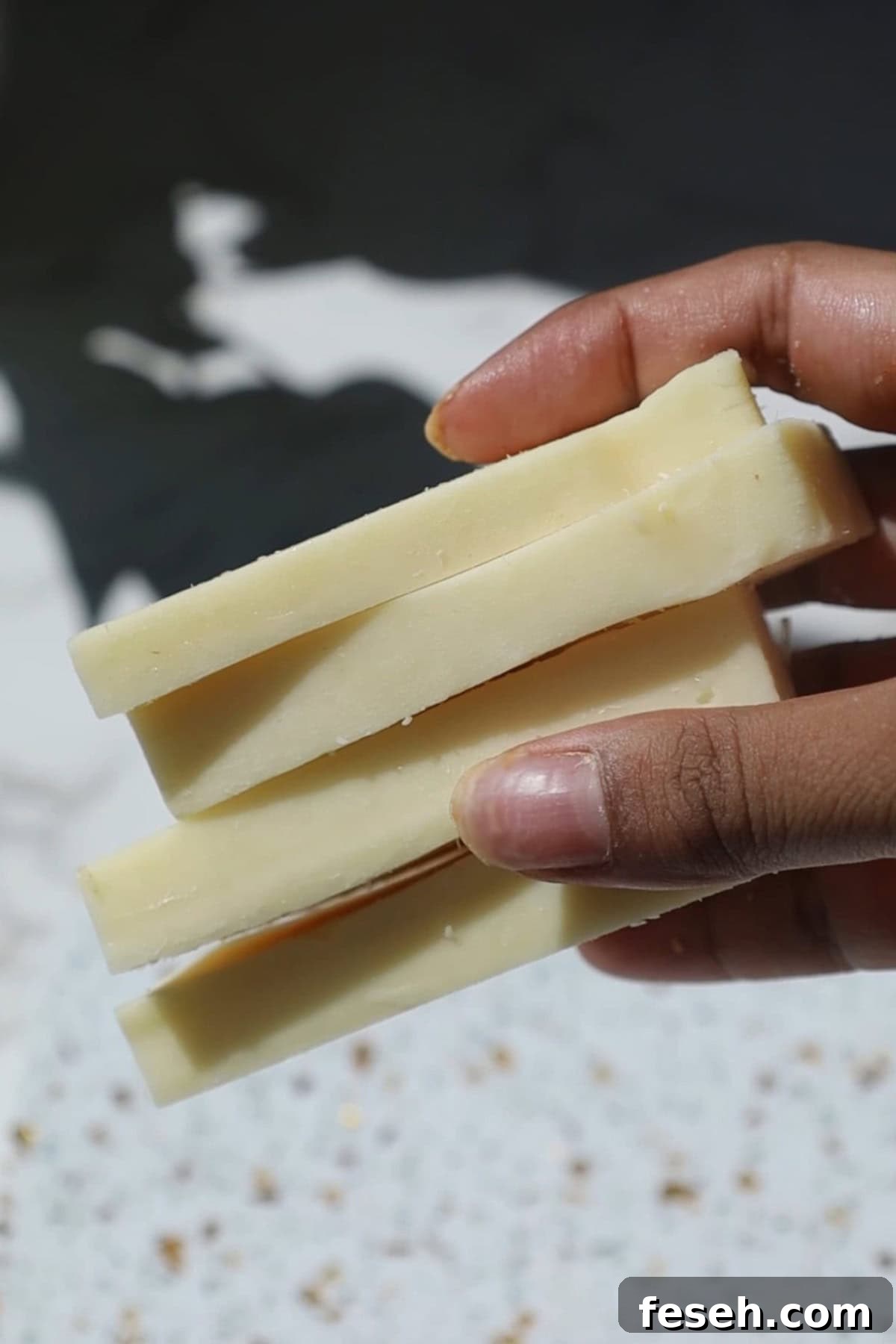 Spicy Honey Mozzarella Sticks Recipe (Video Included) 3 Low moisture mozzarella slices in someone's hand.