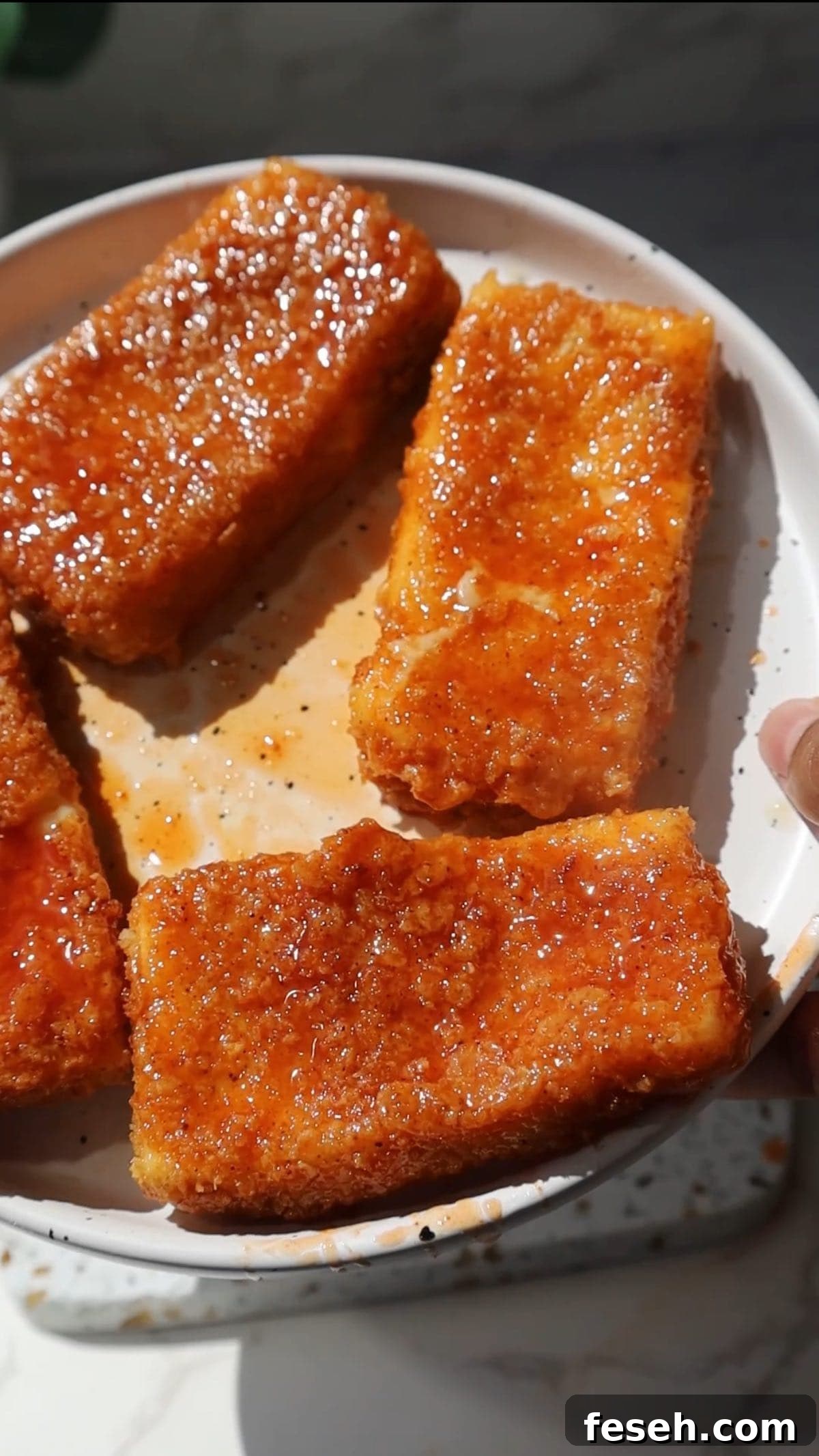 Spicy Honey Mozzarella Sticks Recipe (Video Included) 8 Four hot honey mozzarella sticks on a plate.