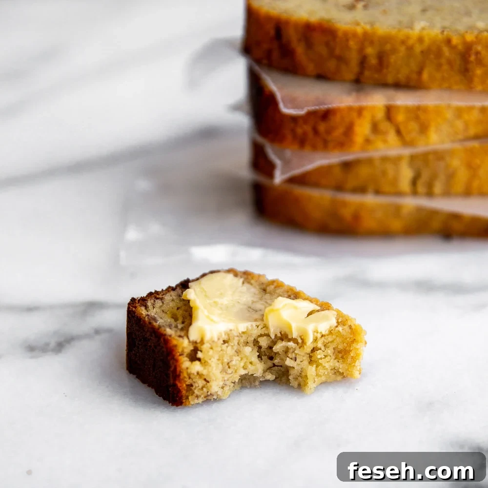 Close up of a buttered slice of paleo banana bread with bite taken out.