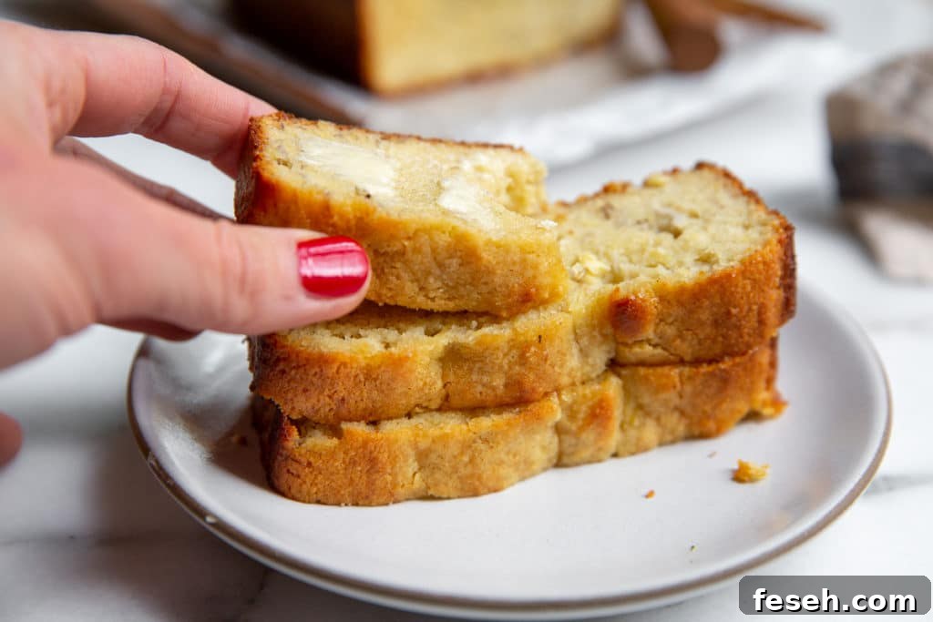 A hand grabbing a piece of banana bread from a stack.