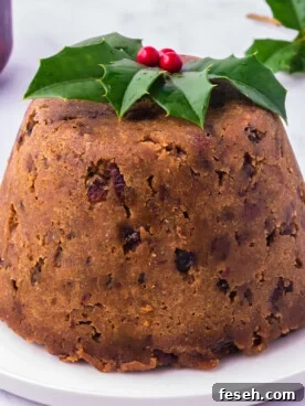 Slow cooker figgy pudding on a white plate with festive garnish.