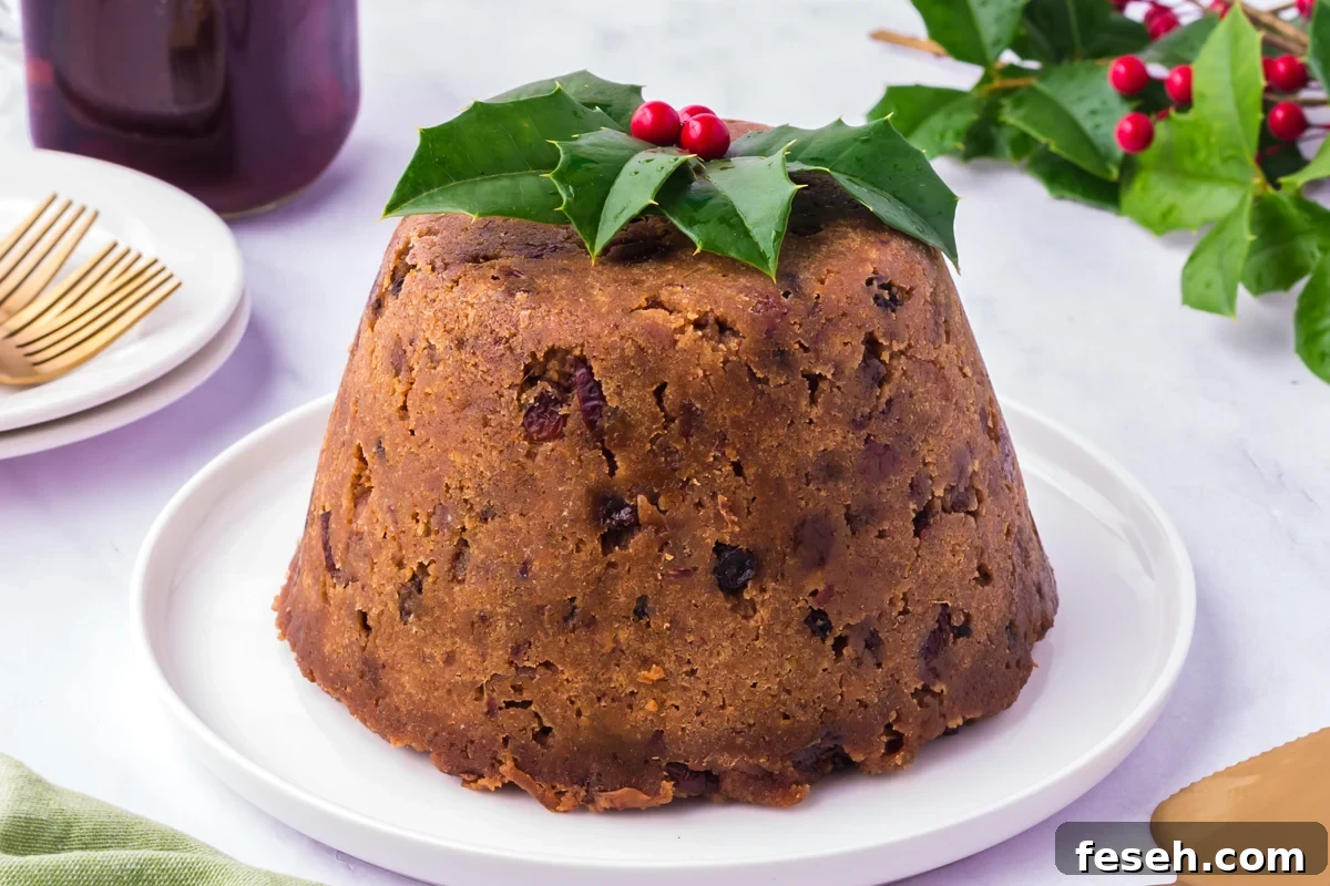 Slow cooker figgy pudding on a white plate with festive garnish.