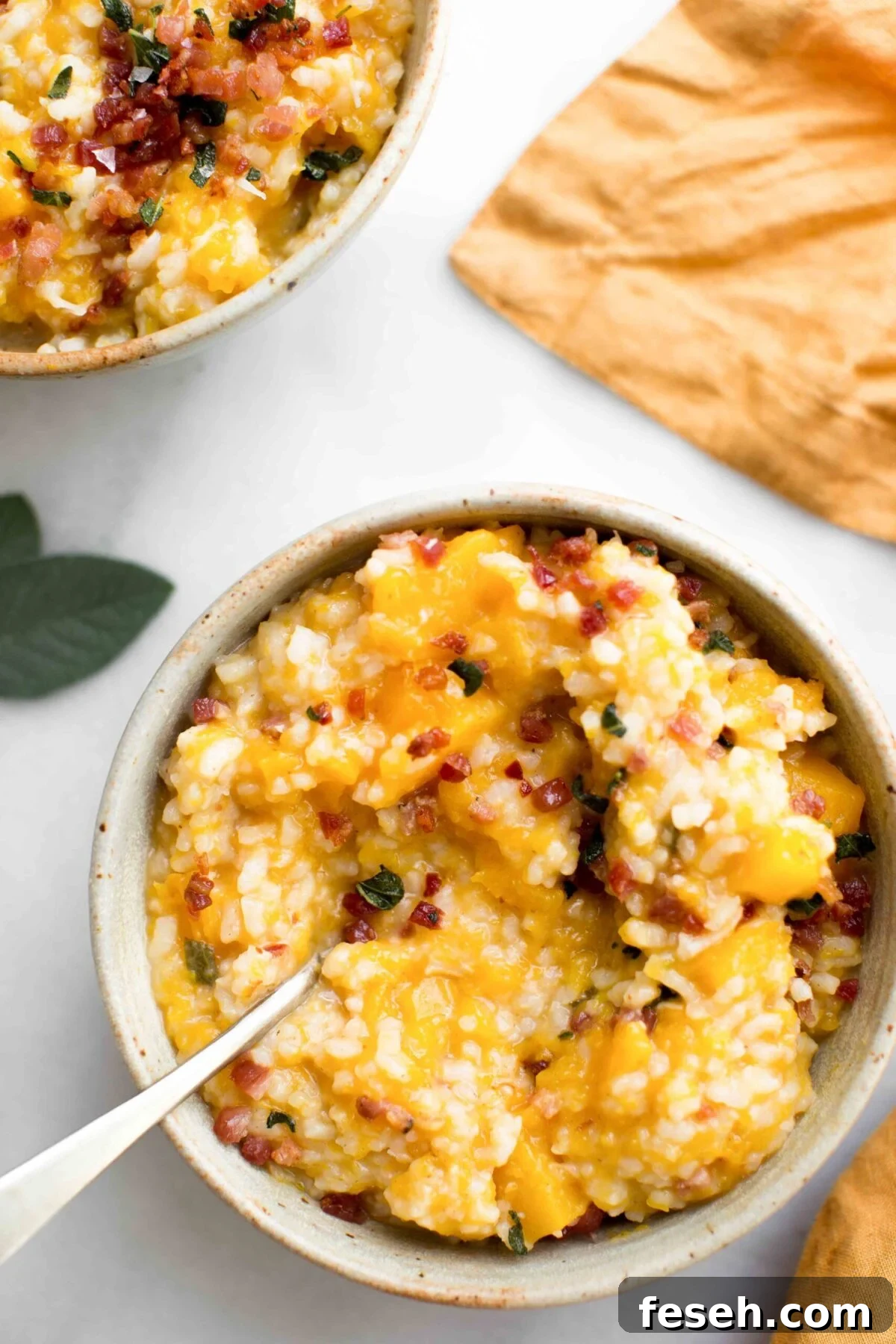 Overhead view of two bowls of butternut squash risotto made in the instant pot topped with pancetta and fried sage