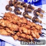 Teriyaki chicken skewers and mushrooms on a platter.
