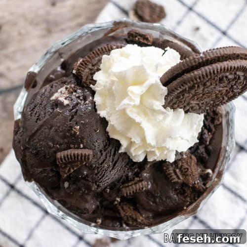 oreo ice cream recipe in bowl with whipped cream and cookie crumbs on top close up