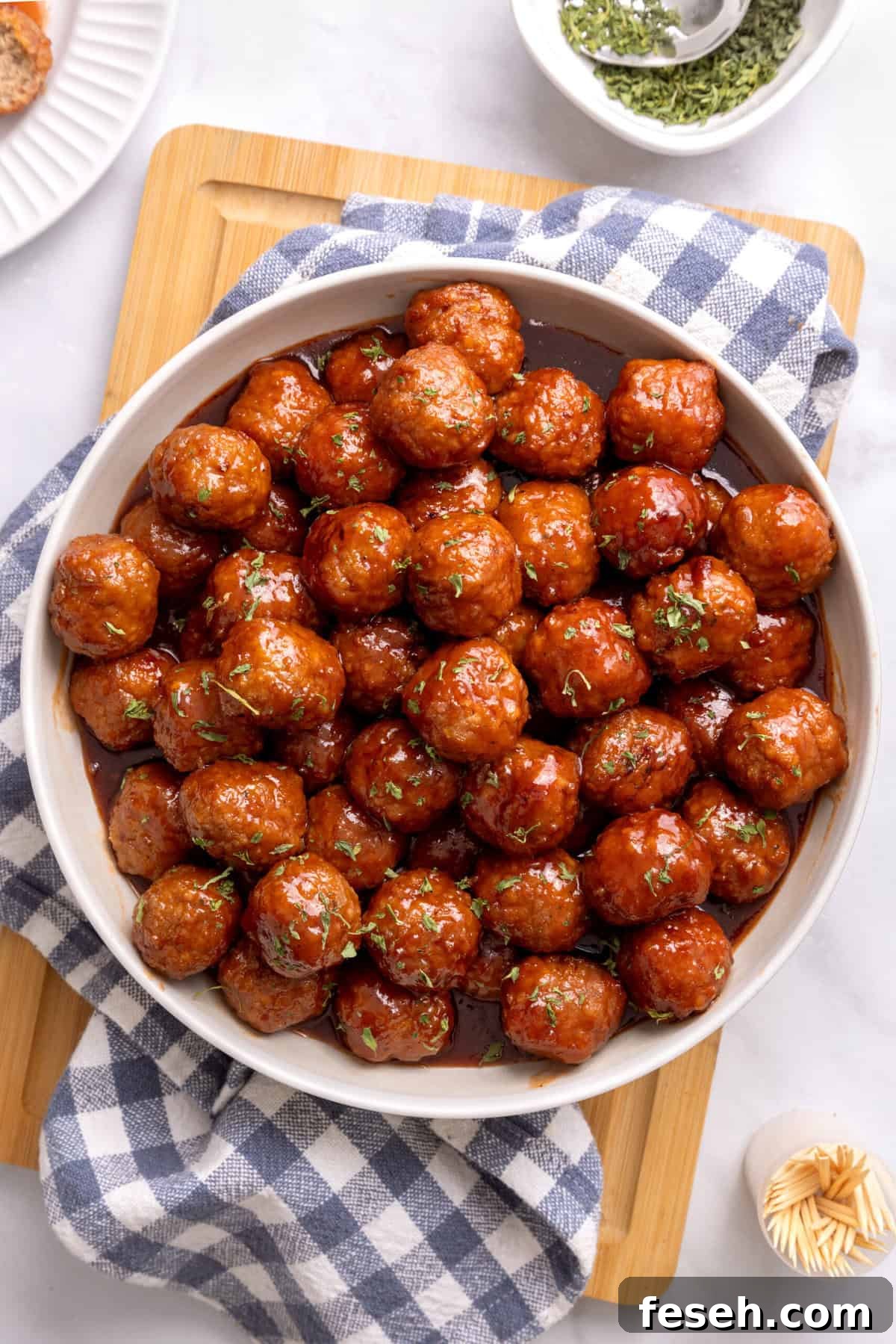 grape jelly meatballs in a white bowl with sauce.
