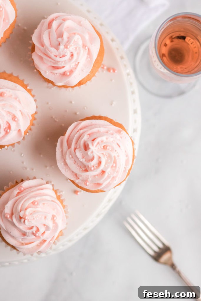 Overhead shot of pink champagne cupcakes on a white cake platter. 