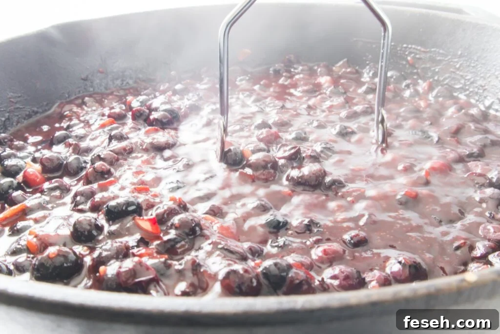 Grilled Pork Chops with Blueberry BBQ Sauce 7 Smashing the blueberries in the skillet using a masher