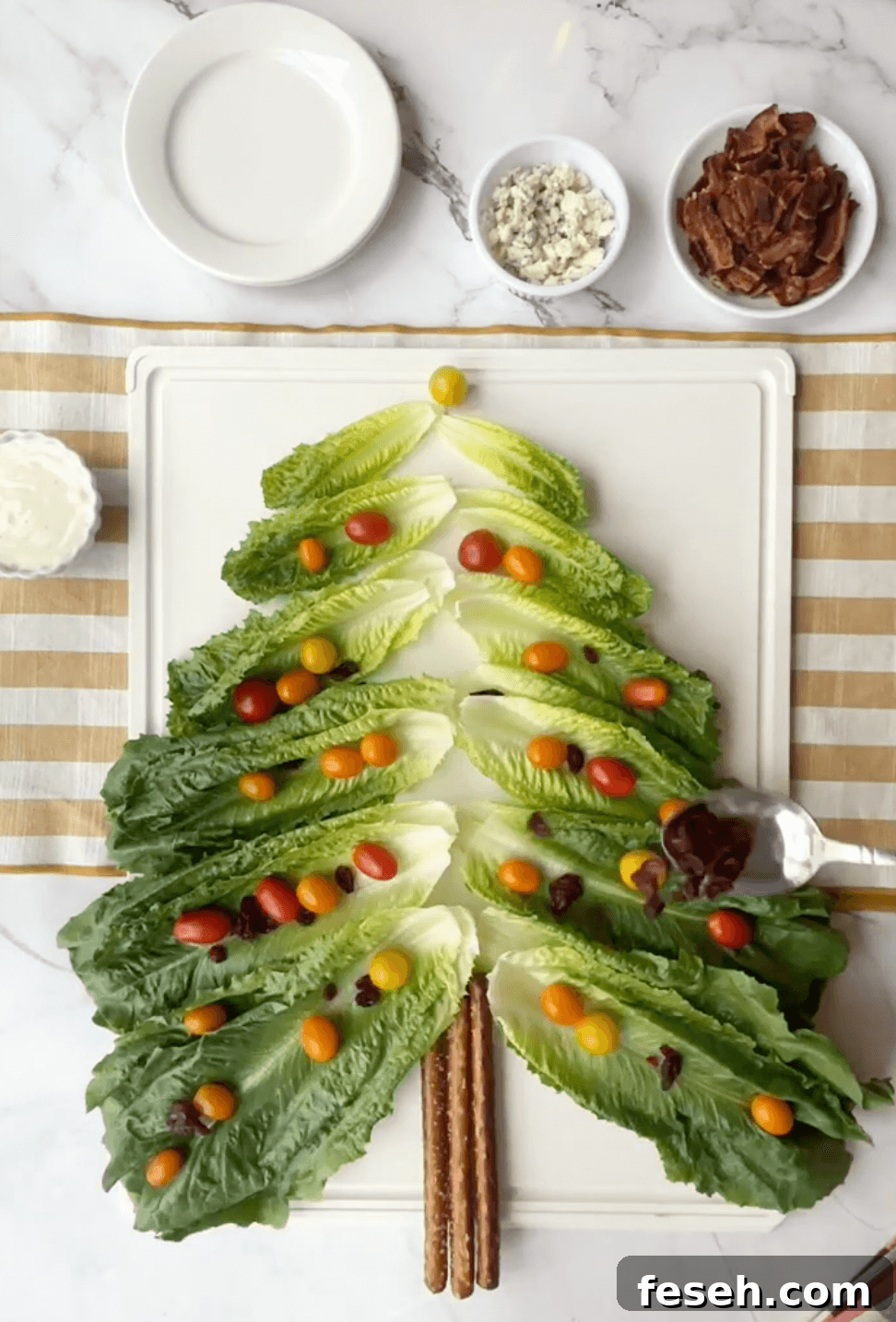Layering the Christmas tree with the dried cranberreis and grape tomatoes