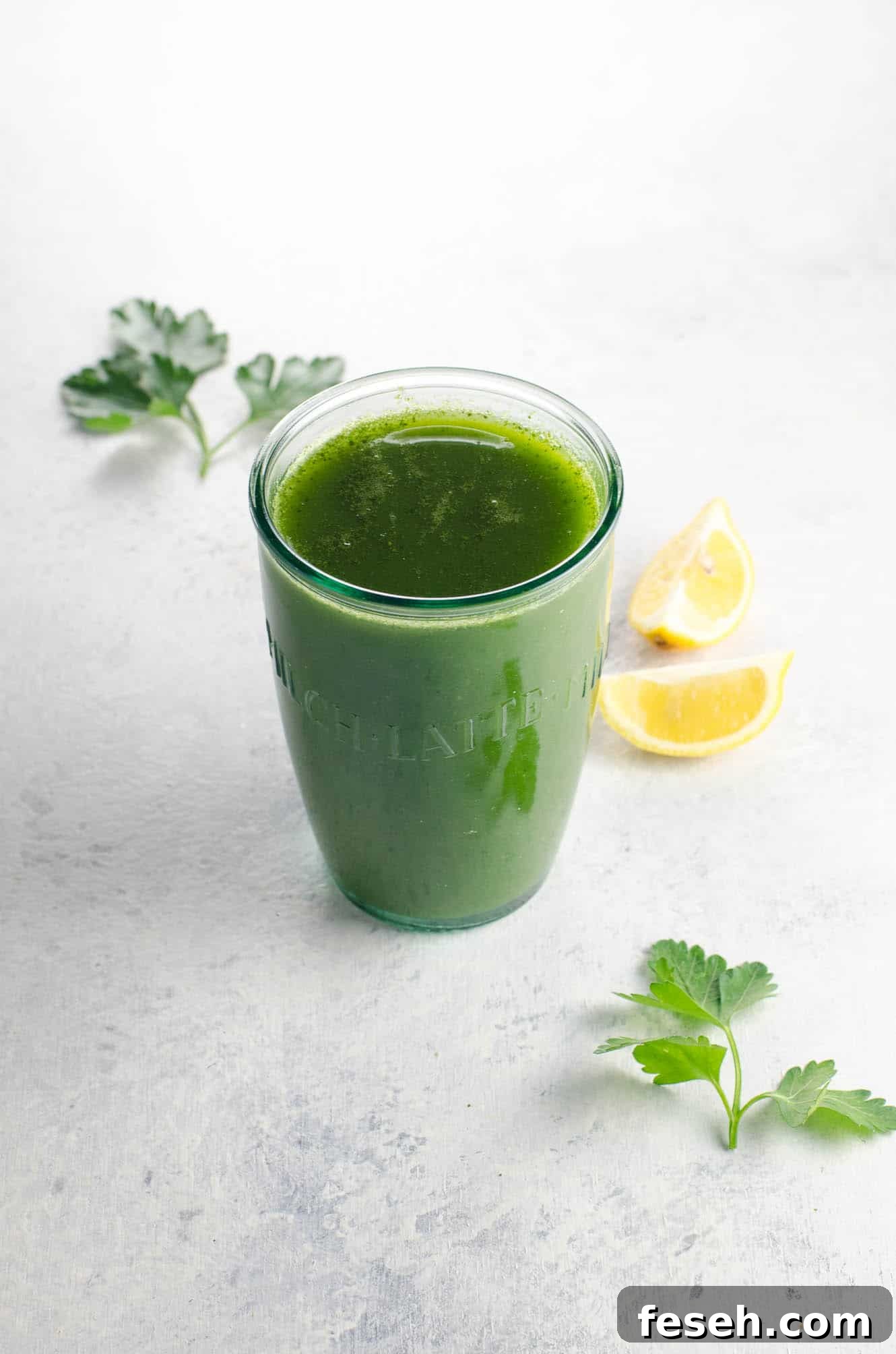 Green Juice Recipes to Support Weight Loss and Boost Metabolism 2 a lovable green juice for weight loss in a glass with parsley and lemon wedges