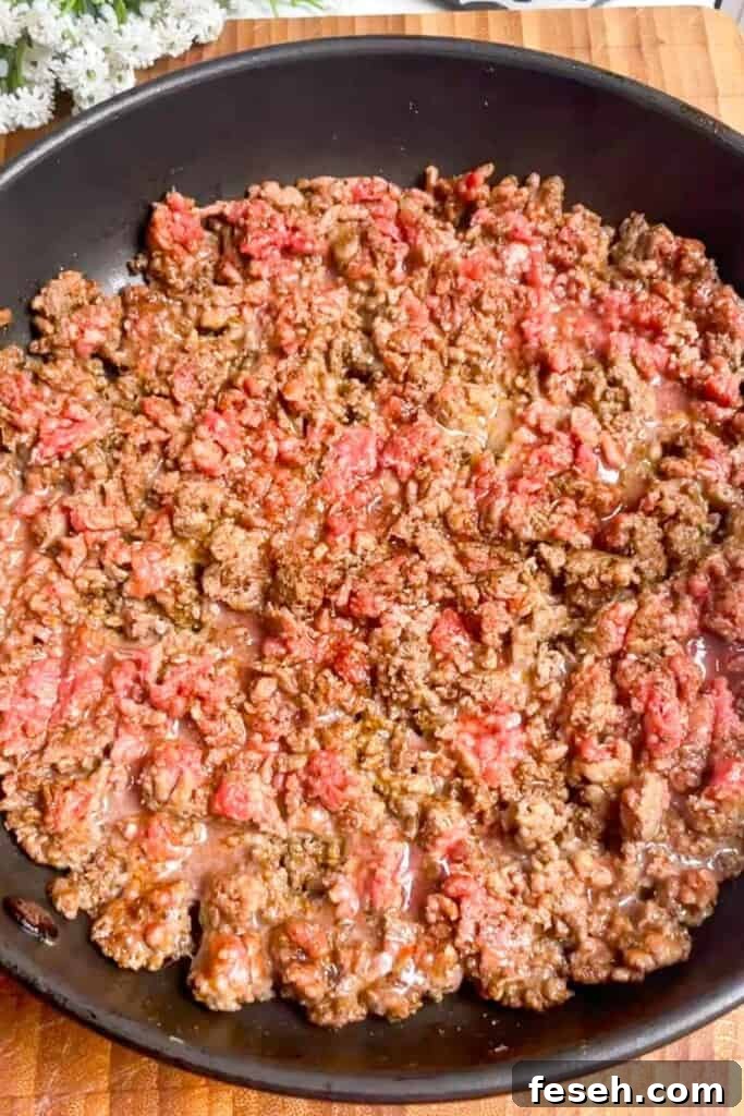 Ground beef browning in a pan.