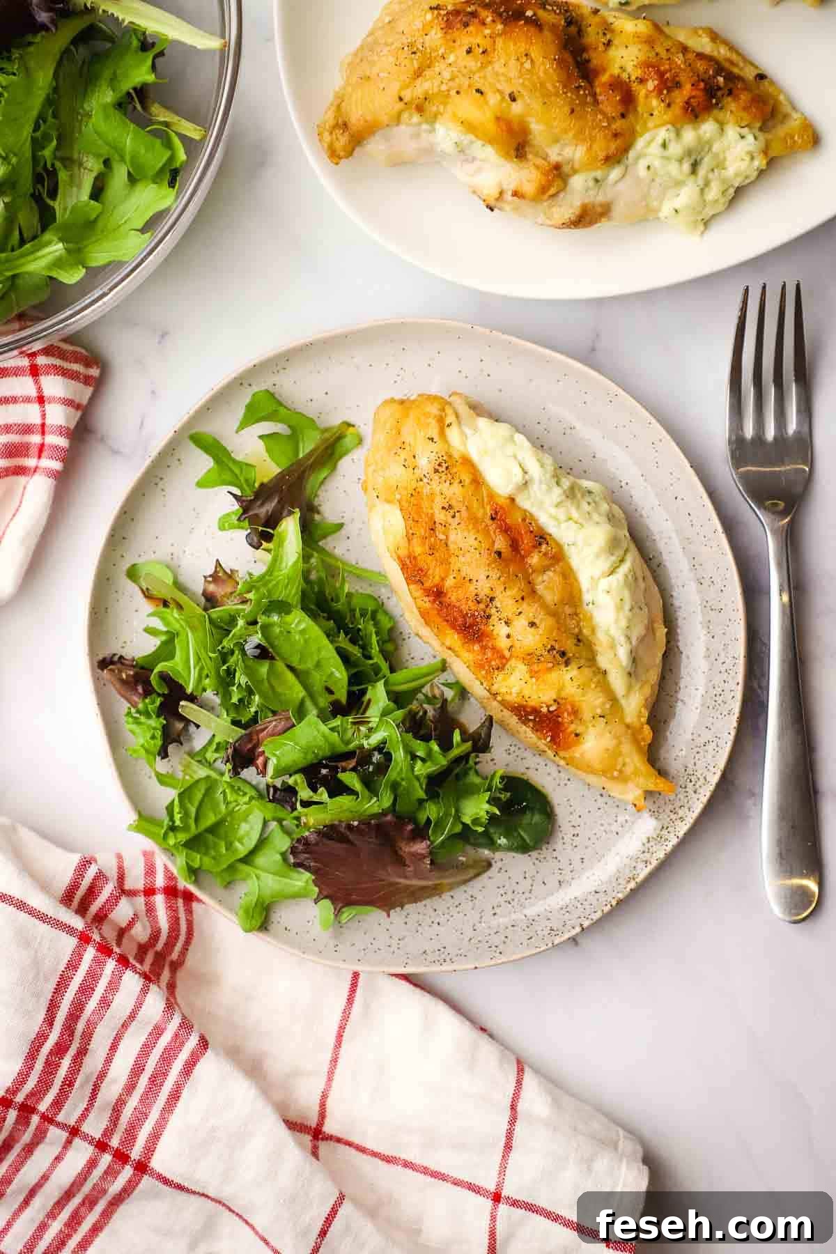 A plate of Boursin stuffed chicken and spring mix salad.
