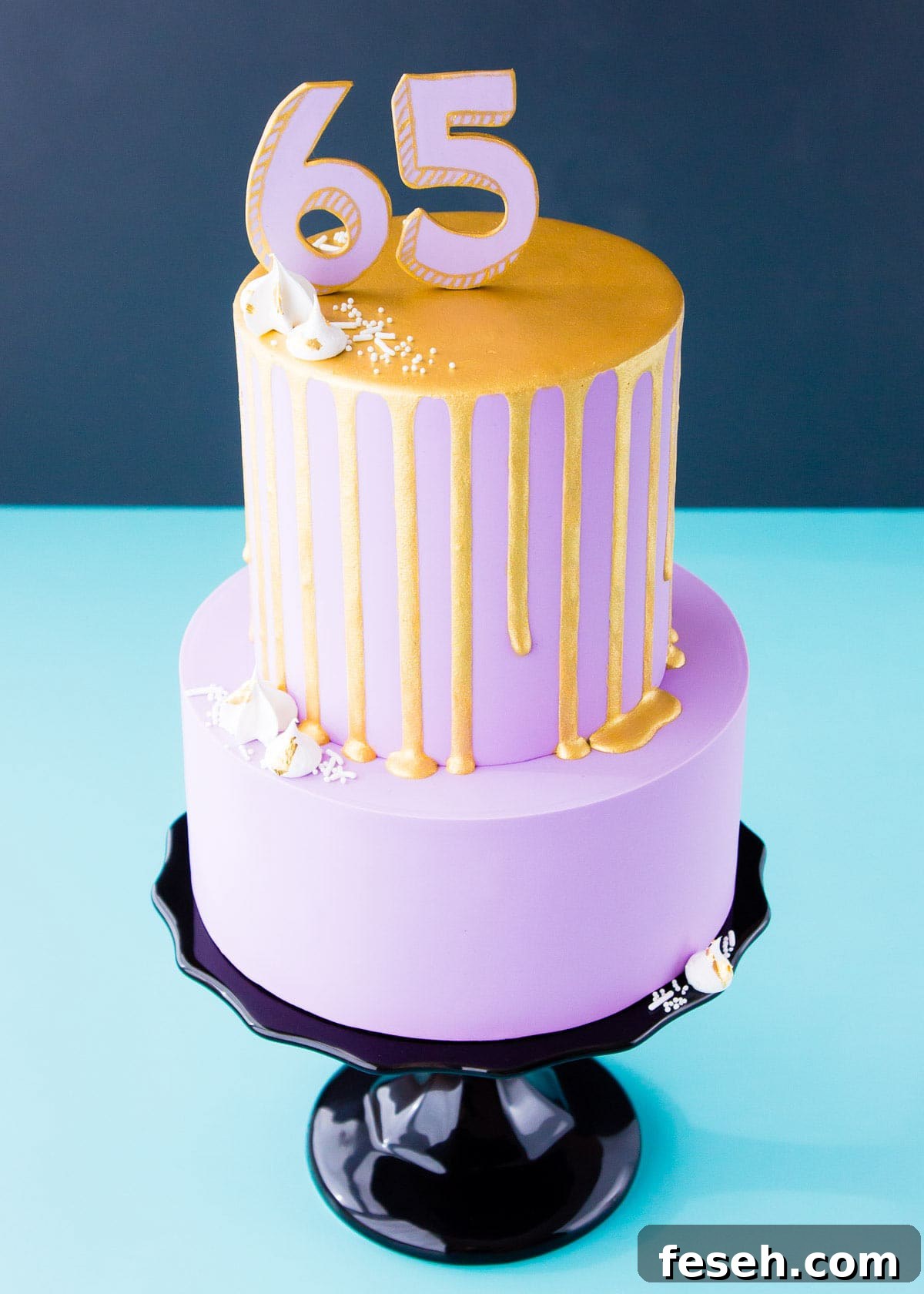 A two-tier cake with a gold painted drip and number topper.