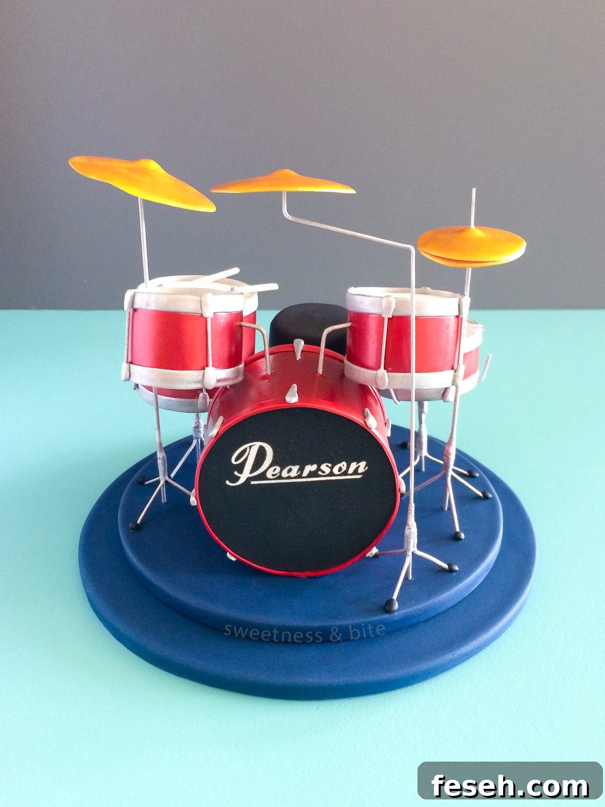 A shiny red drum kit cake topper.