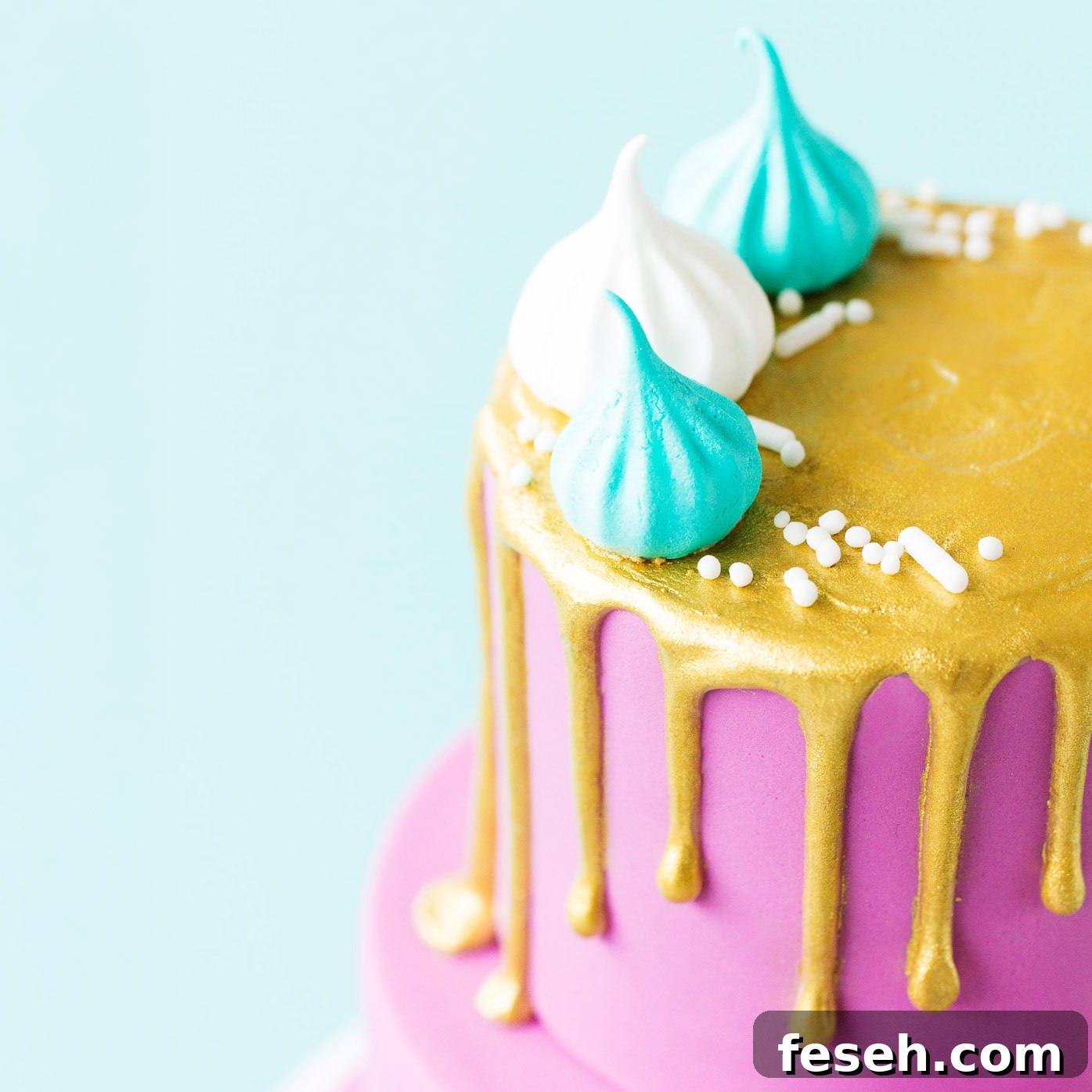 Close up of a mini cake with a metallic gold painted drip.