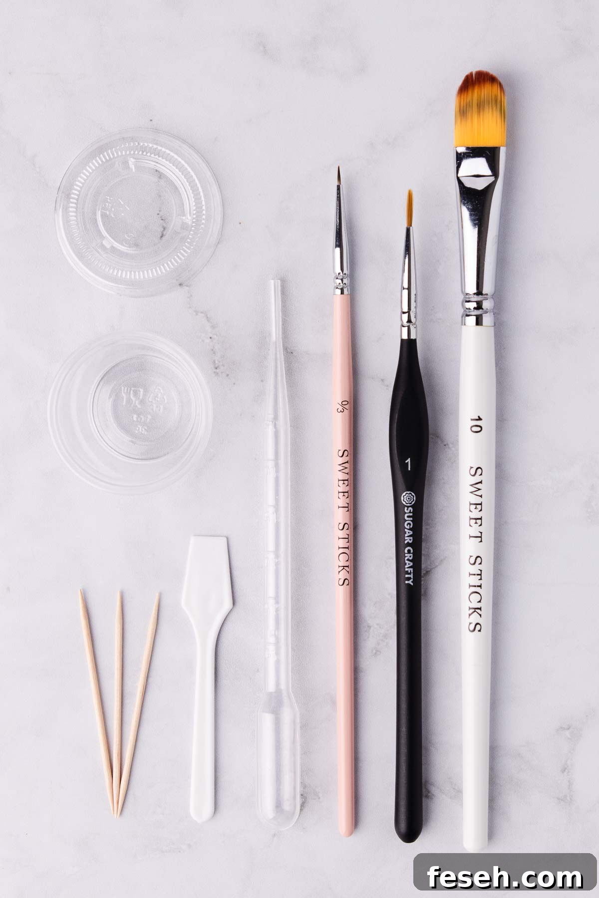 Tools and supplies for making edible gold paint: paintbrushes, toothpicks, a pipette and a small container.
