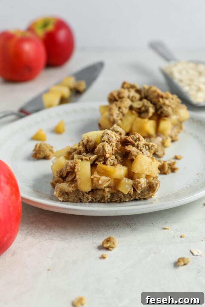 apple pie crumble bars on plate with apples and oats 