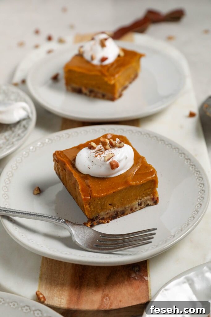 sweet potato pie bars on plate topped with whipped cream and pecans