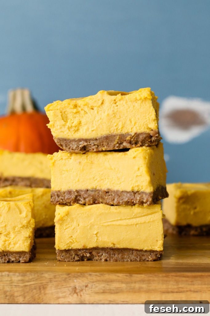 pumpkin cheesecake bars stacked on wooden board