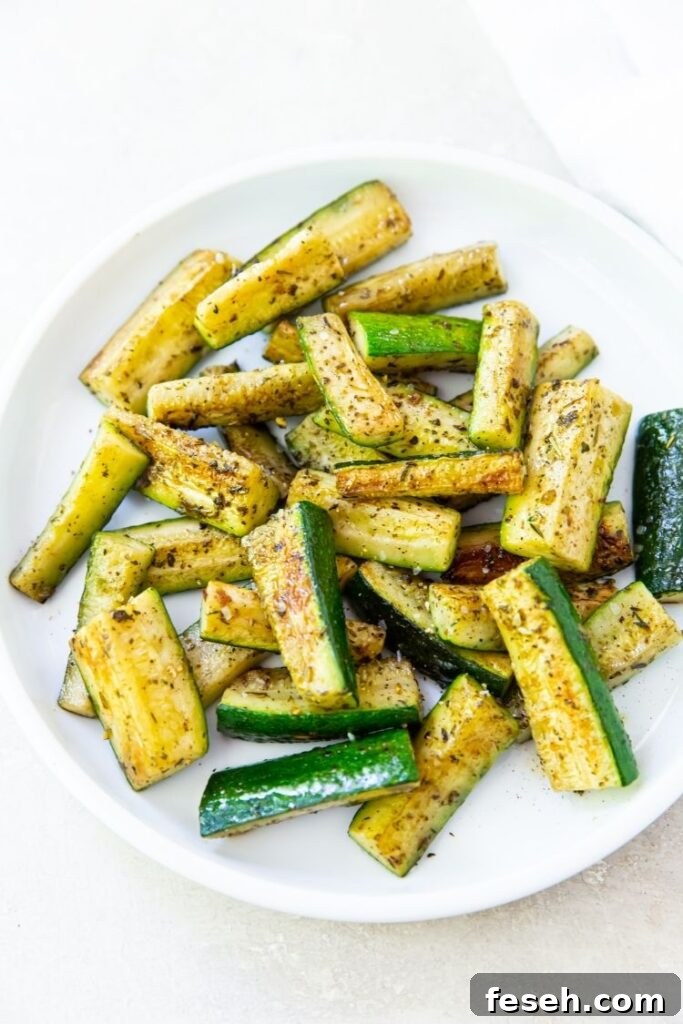Blackstone Grilled Zucchini: Crispy Charred Side Dish 2 Blackstone Zucchini on a white plate on a white background