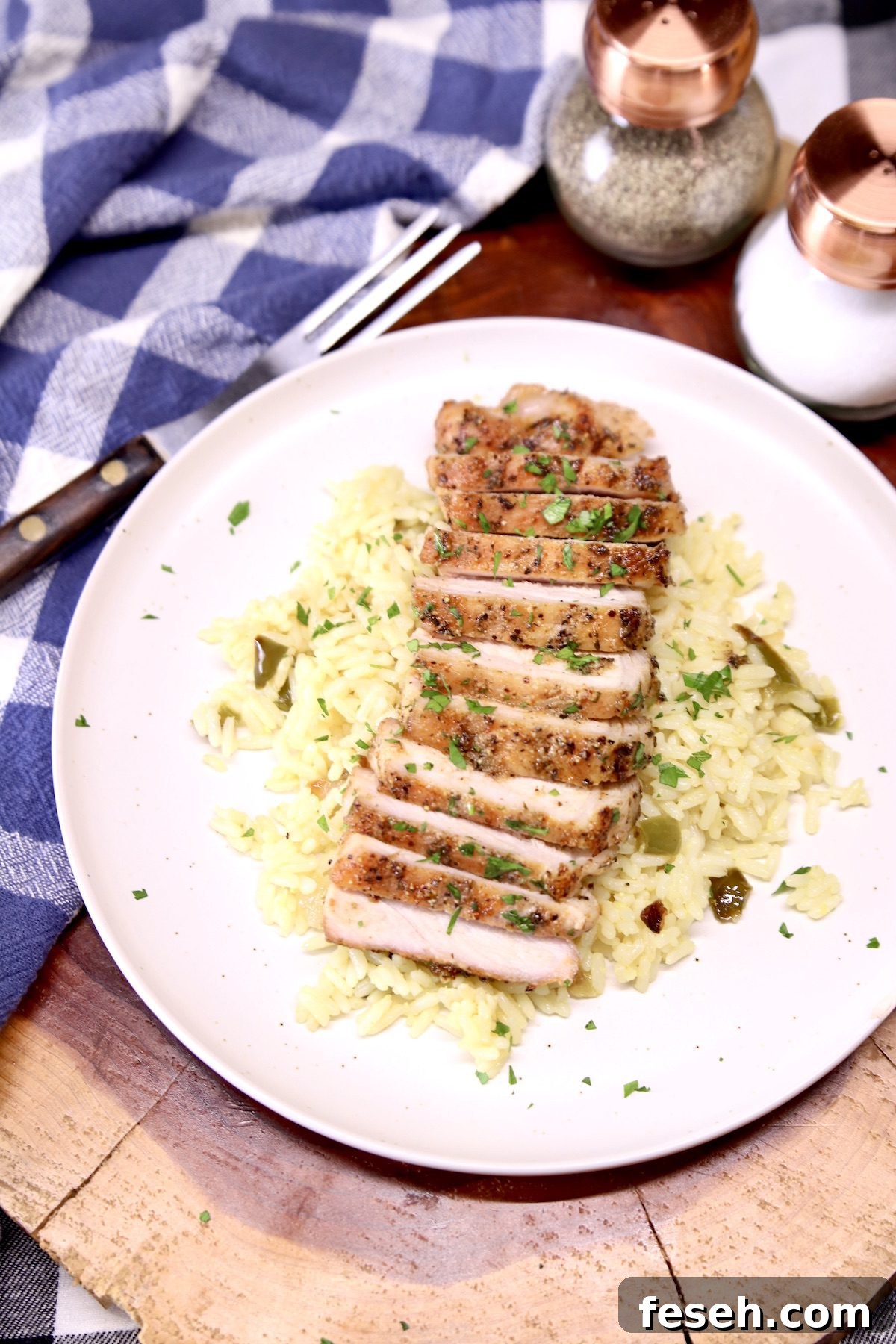sliced pork chop on a plate with rice pilaf