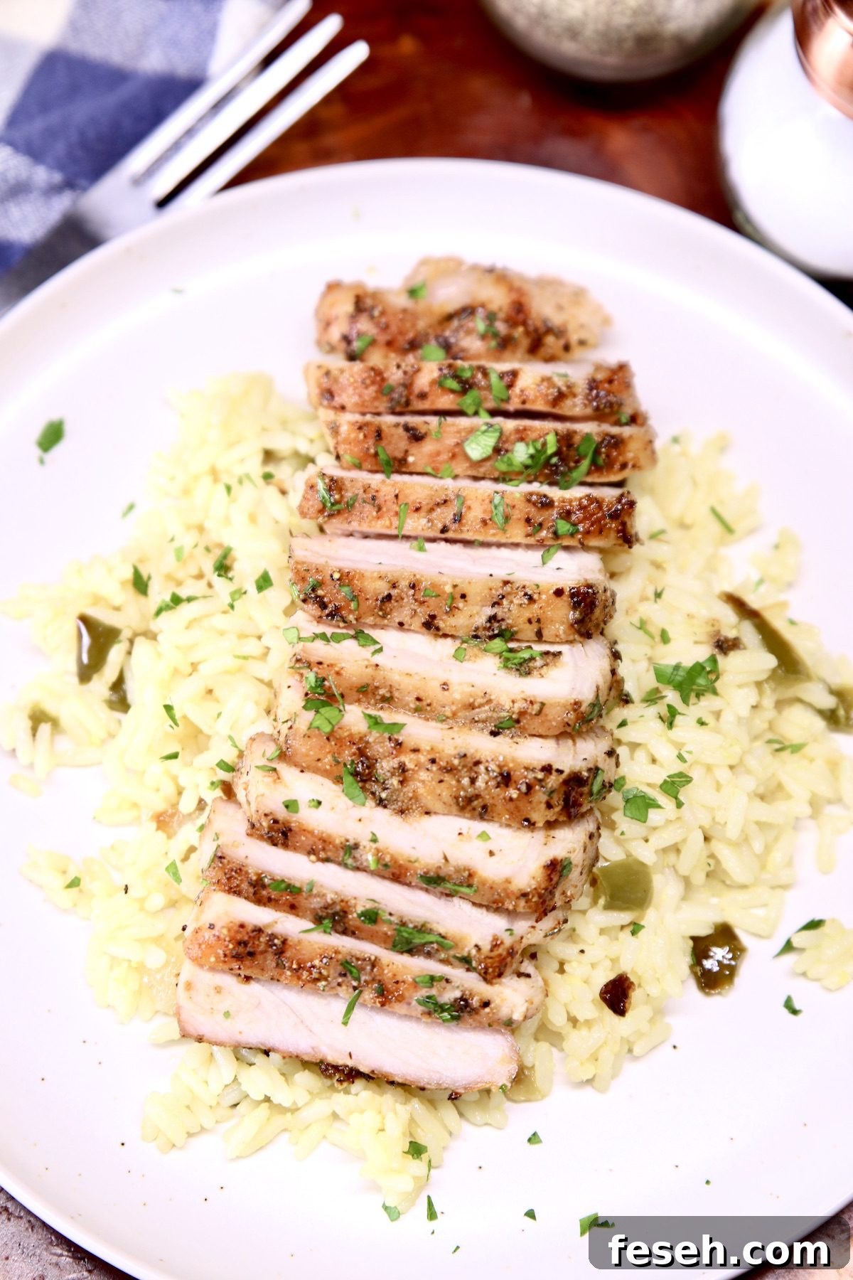 closeup of grilled pork chop, sliced over rice