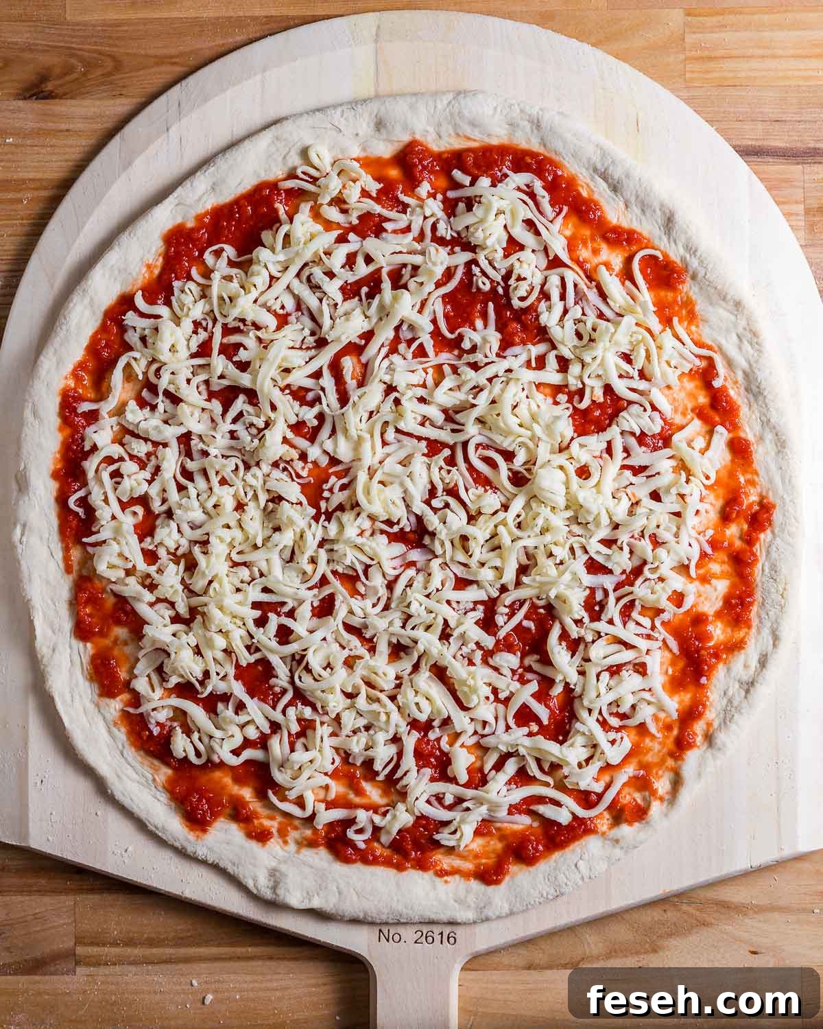 DIY Pizza Baking Steel: How to Make a Homemade Pizza Steel 4 Uncooked pizza on wooden pizza peel.