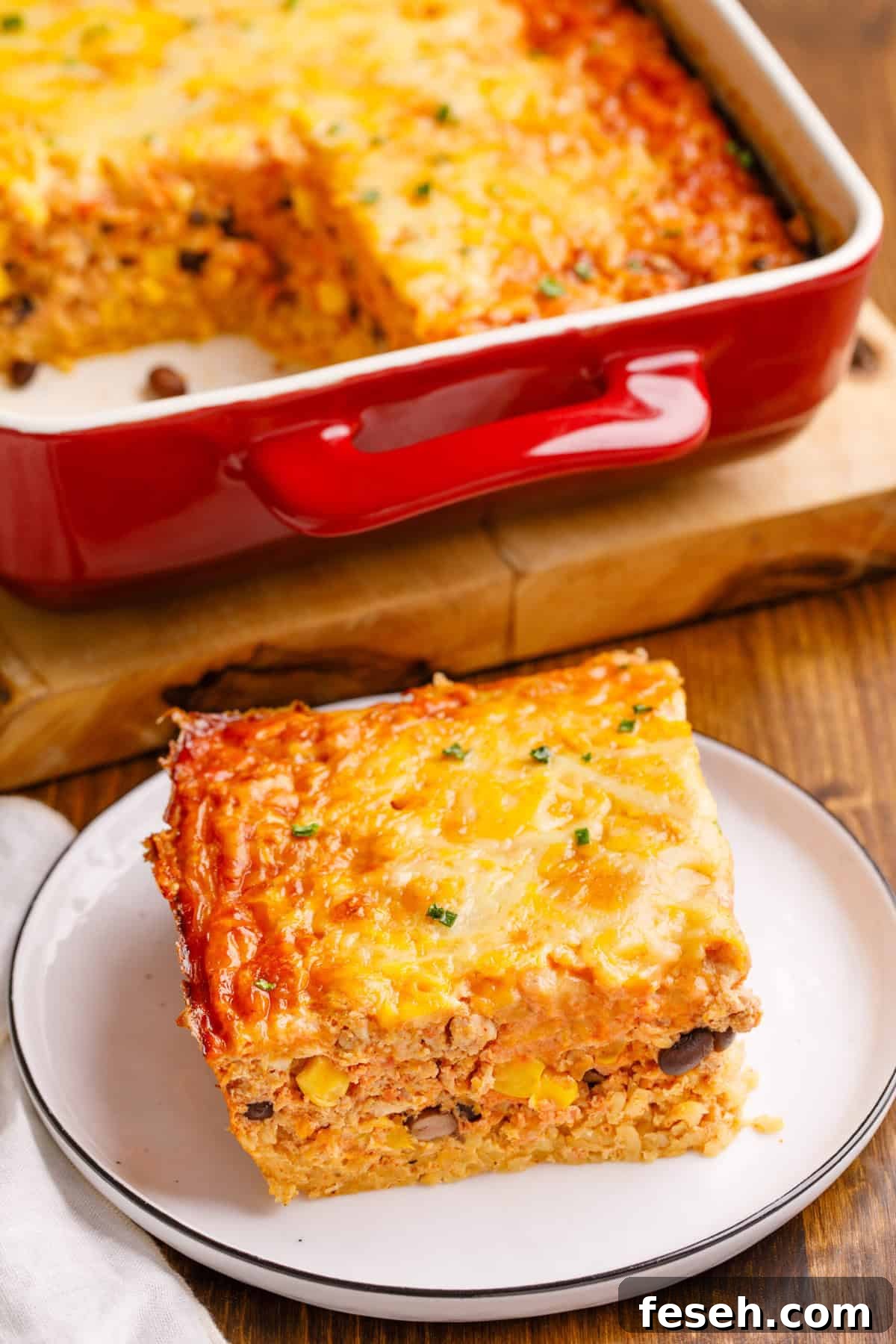 Mexican Breakfast Casserole on a plate with more in the background in a baking dish.