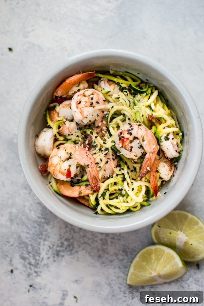 15-Minute Sweet Chili Shrimp with Zoodles Recipe 2 sweet chili shrimp zoodles in a bowl beside lime wedges