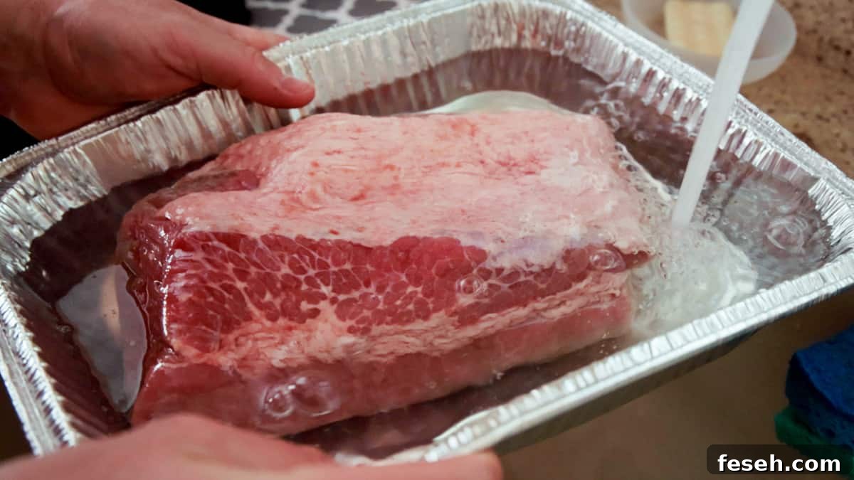 Smoked Corned Beef Recipe for Tender, Flavorful Brisket 4 Soaking raw corned beef brisket in aluminum pan with water.