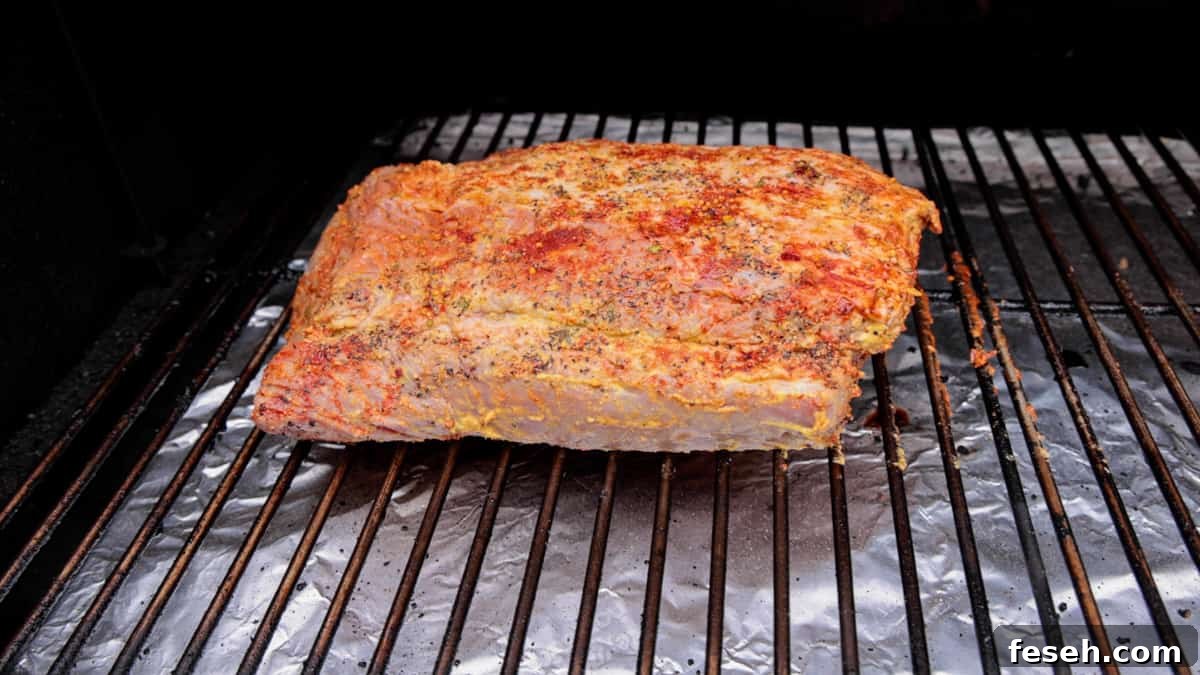 Smoked Corned Beef Recipe for Tender, Flavorful Brisket 7 Seasoned corned beef on smoker grate with temp probe inside.
