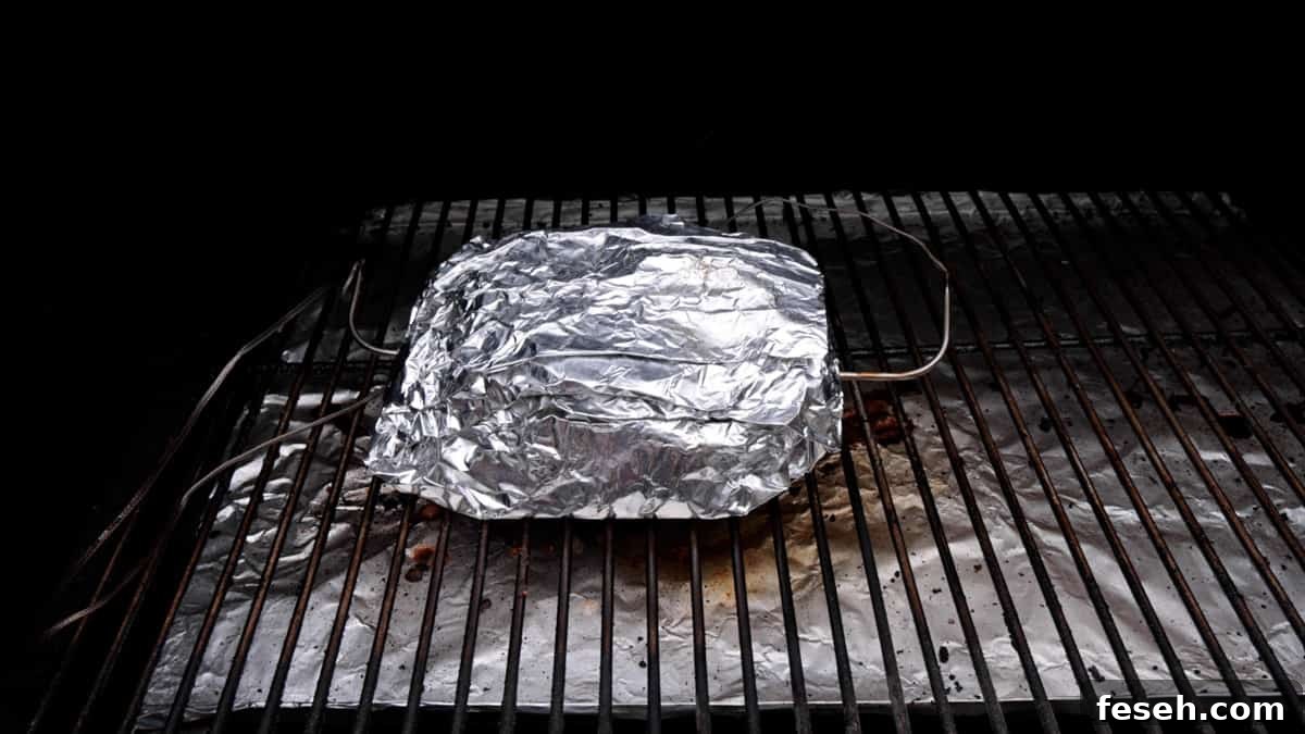 Smoked Corned Beef Recipe for Tender, Flavorful Brisket 8 Foil wrapped corned beef on grill.
