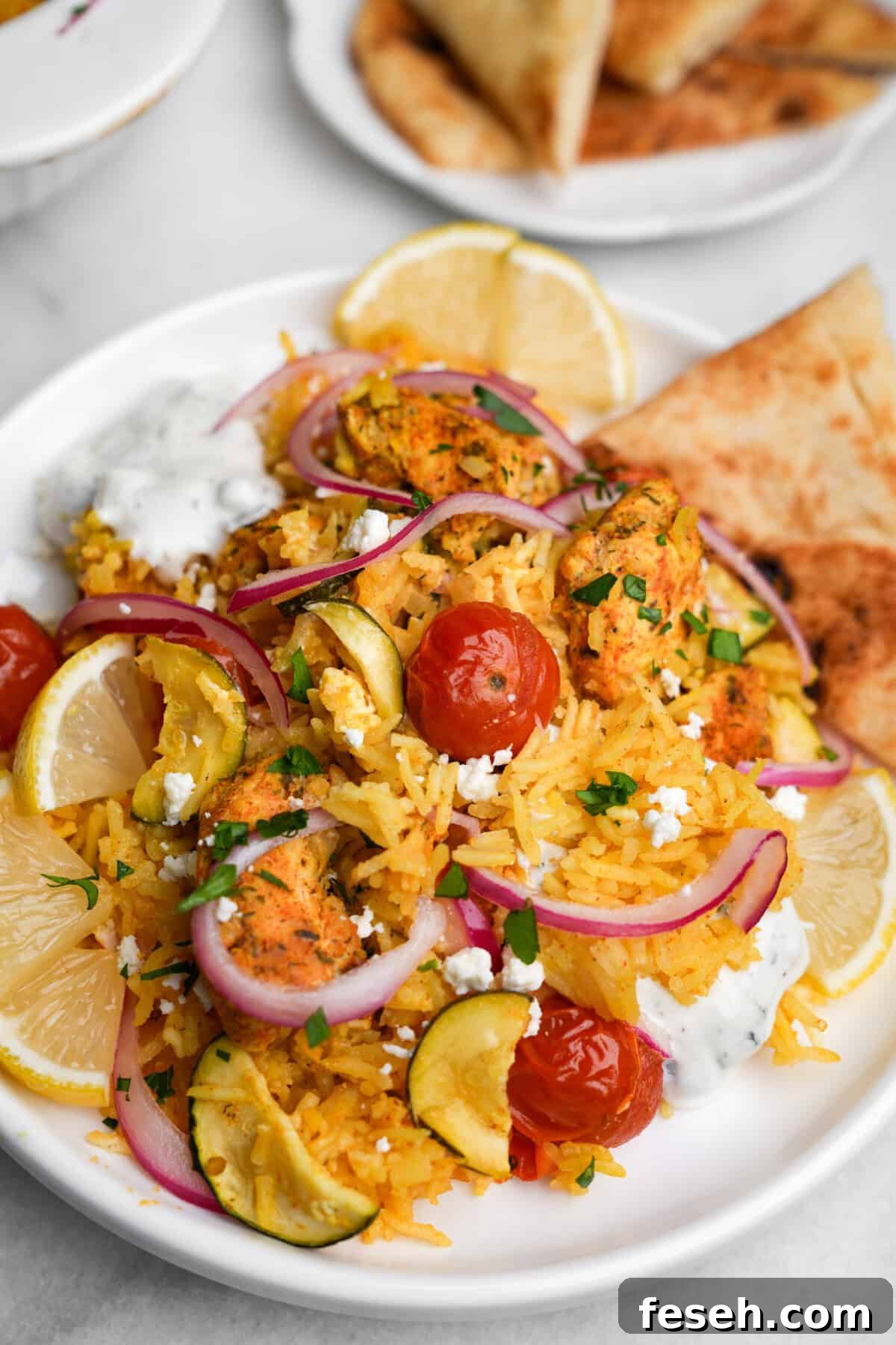 Greek-Style Chicken Tzatziki Casserole 3 chicken tzatziki casserole portioned on a plate with pita bread