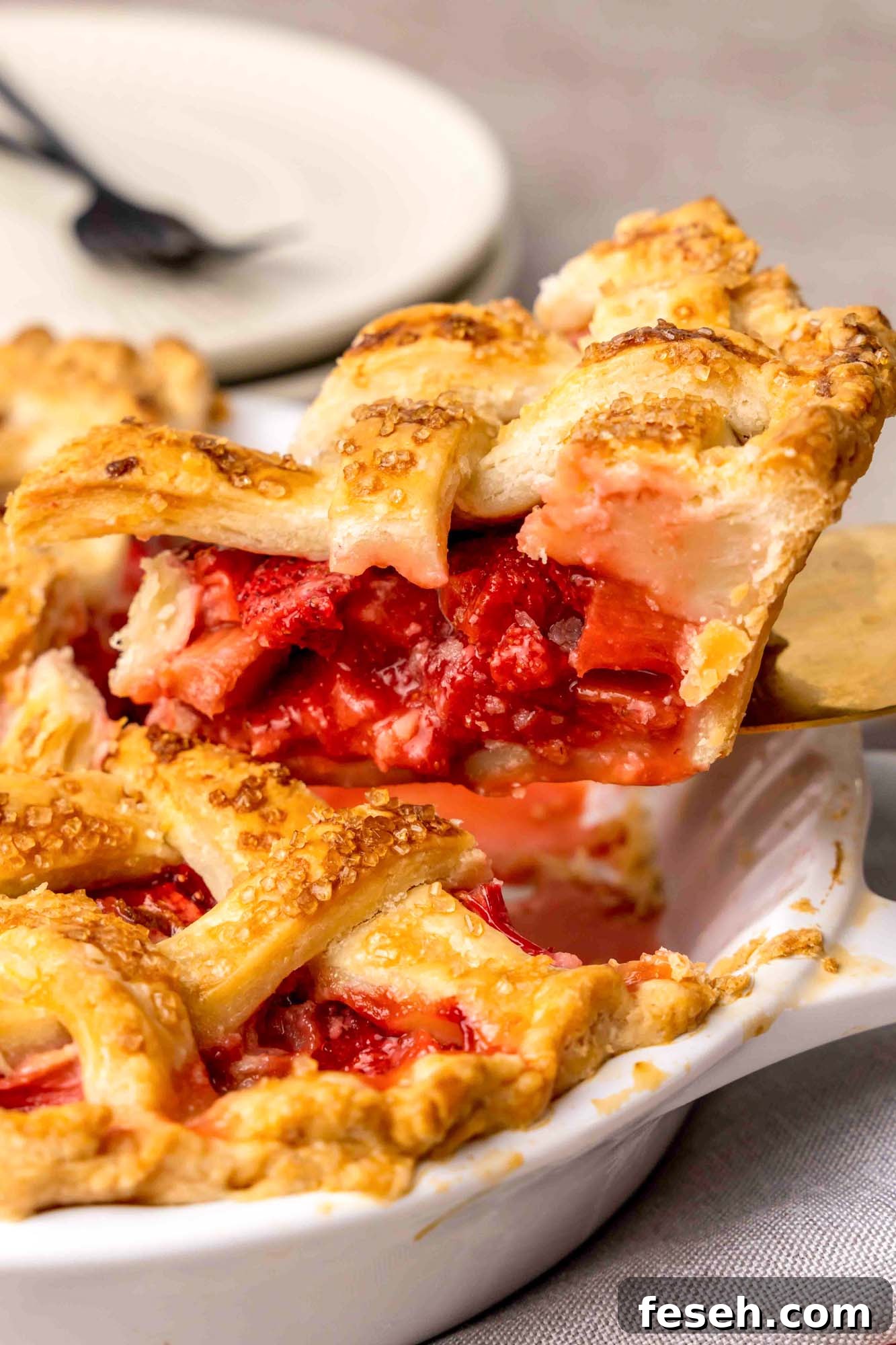 Strawberry Rhubarb Pie Recipe with Buttery Crust 7 Taking a slice of Strawberry Rhubarb Pie to serve