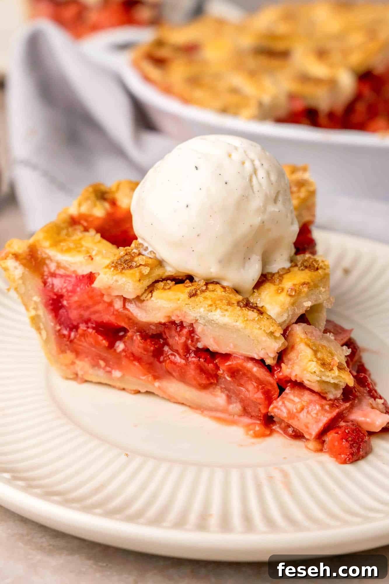 Strawberry Rhubarb Pie Recipe with Buttery Crust 9 A slice of the pie served with a scoop of vanilla ice cream