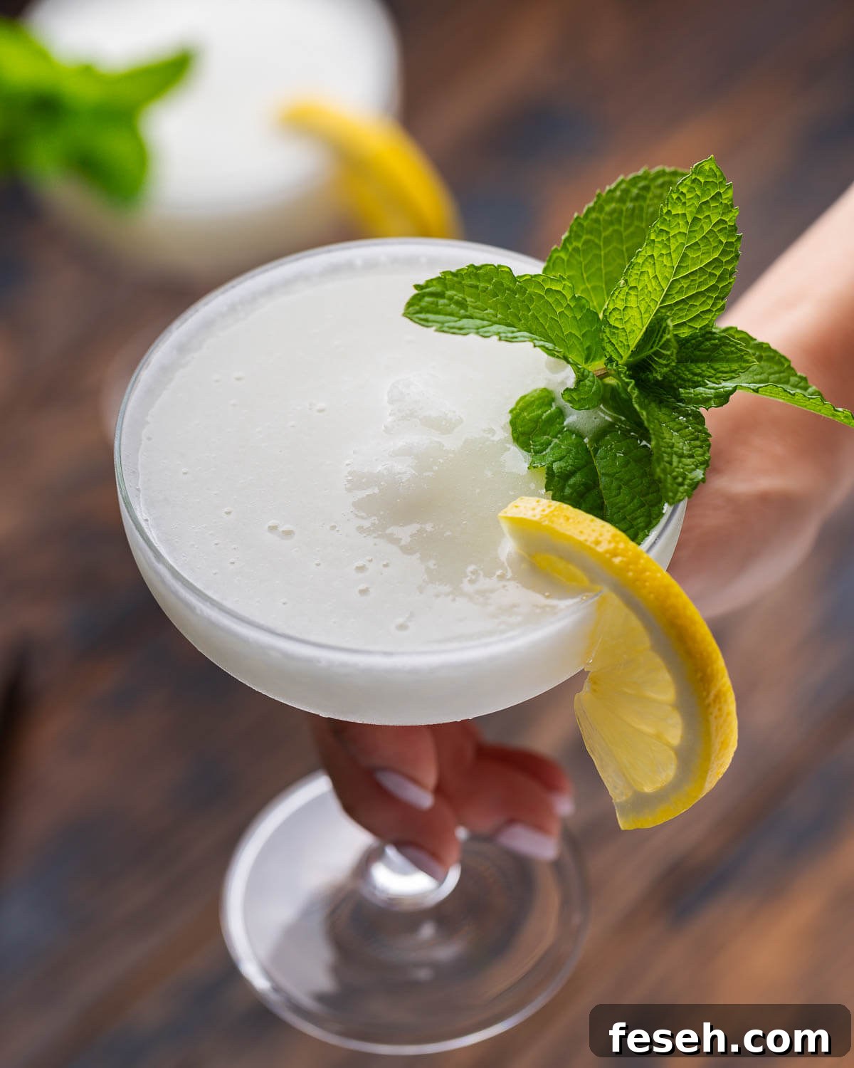 Sgroppino: Italian Lemon Sorbet and Prosecco Cocktail 2 Hand holding sgroppino cocktail.