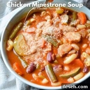 Hearty Chicken Minestrone Soup with Vegetables 11 chicken minestrone soup in a bowl served with grated parmesan cheese & a spoon