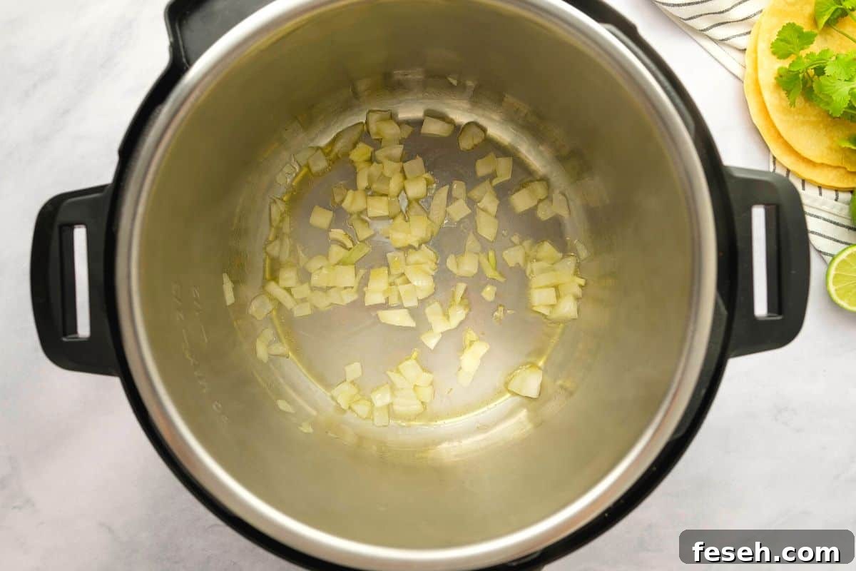 Instant Pot Tortilla Soup Sauteed onion in oil in inner pot for base of Chicken Tortilla Soup.